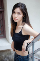 Portrait of thai china adult beautiful girl black shirt blue jeans relax and smile