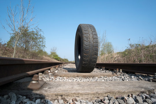 Big rubber truck tyre standing up on a railway track