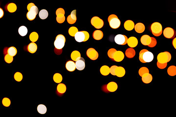 Gold abstract bokeh background. defocused and blurred many round yellow light on dark background