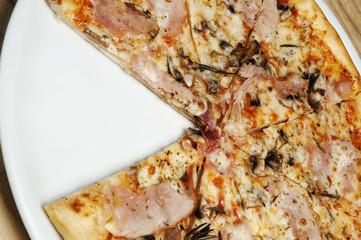 Delicious pizza with cheese, mushrooms and tomatoes on a wood background