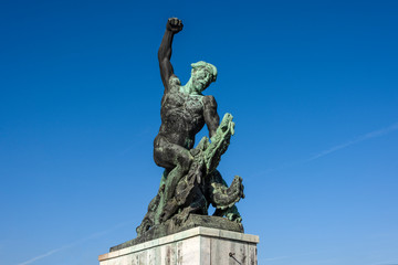 Hungary, Budapest, Gellert Hill: Dragon Slayer statue next to famous Liberty Statue or Freedom Statue above the city center of the Hungarian capital with blue sky in the background - travel liberation