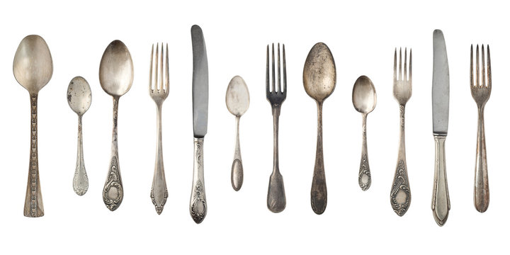 Top view of beautiful vintage silver knifes, spoons and forks  isolated on white background. Silverware.
