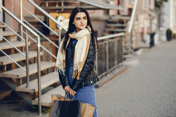 beautiful elegant girl walking around the city with shopping bags