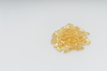 Yellow transparent capsules on a white background. Dietary supplements omega-3, omega-6 and...