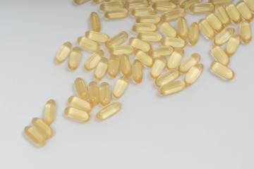 Yellow transparent capsules on a white background. Dietary supplements omega-3, omega-6 and...