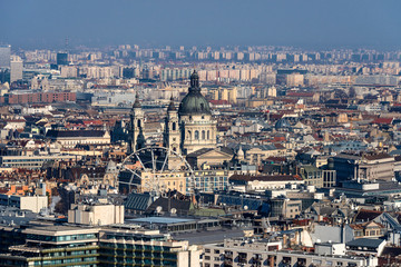 Obraz premium Hungary, Budapest: Skyline with St. Stephen's Basilica from above and mass of houses, buildings, apartments, rooftops in the city center of the Hungarian capital - concept urban travel.