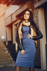Fototapeta premium A stylish and beautiful girl standing in a summer city