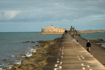 People are walking on the fortifications dyke in the harbor of Cherbourg. Normandy, France