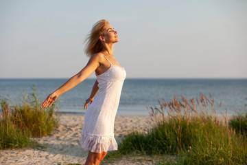 happy woman on the beach at sunset