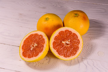 Ripe juicy grapefruit on a white wooden table