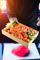 Close up image of sliced salmon sashimi in chef hands . Traditional Japanese food well known as Sashimi