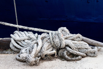 Close up of rope in front of blue boat at asian port