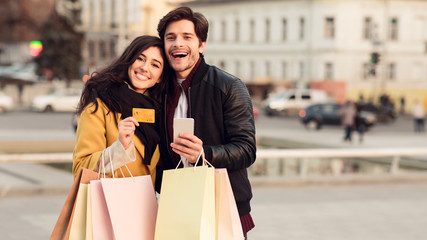 Payment and shopping online. Couple with credit card and bags