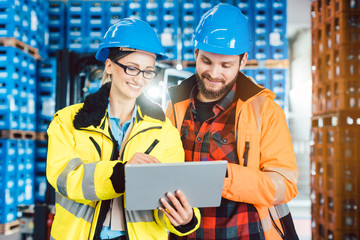 Woman and man as workers in logistics center using computer