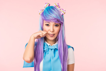 Asian anime girl in wig posing isolated on pink