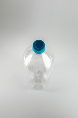 Top view of a empty  bottle of a liter and a half of mineral water with  sea green cap and sealing ring on a white background, and space for inserts.  Reuse, Conservation, Sustainable concept.