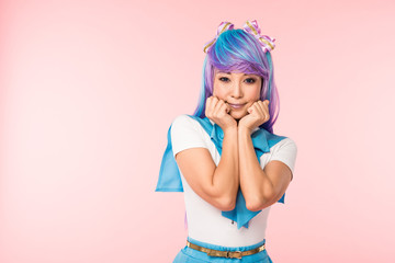 Pretty asian anime girl in purple wig posing isolated on pink
