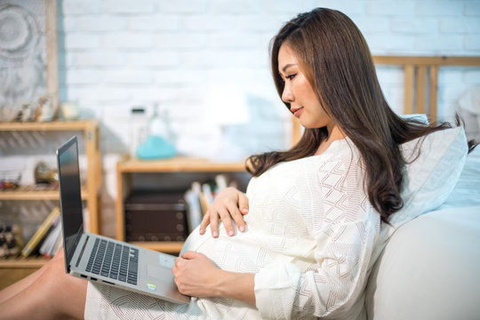 Pregnant asian woman using laptop