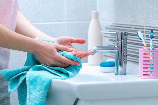 Woman Wipe Hands Dry With Towel After Washing In Bathroom At Home. Hygiene And Hand Care.