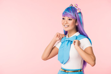 Smiling otaku girl in purple wig looking away isolated on pink