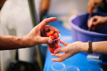 Volunteers provide food for beggars : Concepts Feeding and help : The hands of the rich give food...