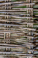 Gray wet texture weave an old surface of a furniture. Blurry backdrop of a vintage.  Background fragment of an old wicker chair made of wood twigs. Soft focus. Closeup.