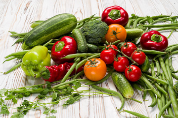 vegetables laid out on the table, tomatoes, cucumbers, zucchini, asparagus, bell peppers, parsley, hot peppers,
