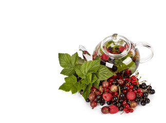 Teapot with fruit tea and green leaves
