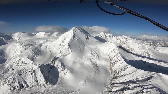 The plane flies over the Himalayan mountains. The tops of the mountains are covered with snow. The area of the eight-thousandth Shishabangma. Tibet.