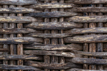 Gray background fragment of an old wicker chair made of wood twigs. Wet texture weave an old surface of a furniture. Blurry backdrop of a vintage. Soft focus. Closeup.