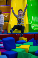 Fototapeta na wymiar little boy sliding in kindergarten park