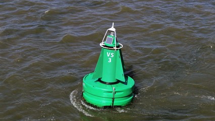 Green solar powered buoy floating on the wadden sea near the island Vlieland