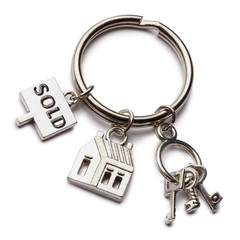 Keychain with mini keys, house and sign "sold", isolated on white background