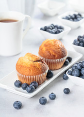 Muffins and blueberry on white table.