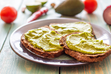 Sandwiches with avocado on the blue wooden background.
