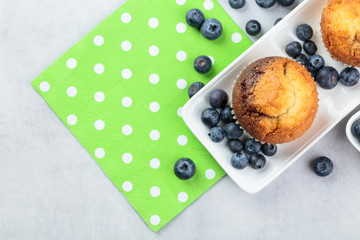 Muffins and blueberry on white table.