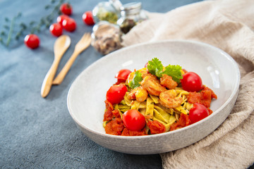 Cooked pasta with peeled shrimp, coconut milk sauce and broccoli