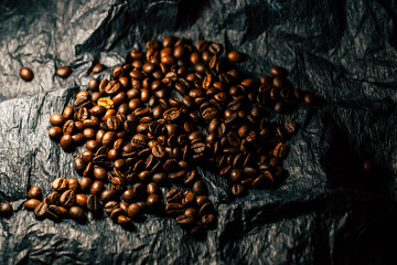 Coffee grains on a black background with a cup