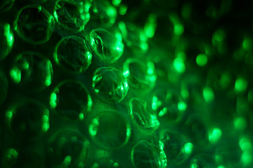 Green cellophane texture with air bubbles, abstract, macro