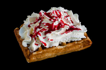 Belgium waffle with cream and strawberry syrup isolated on black background