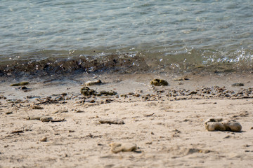Waves along the beach clash with sand, gravel and sand.