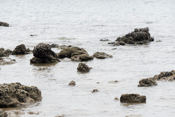 Rocks by the sea in the afternoon The surrounding sea is reflected in white.