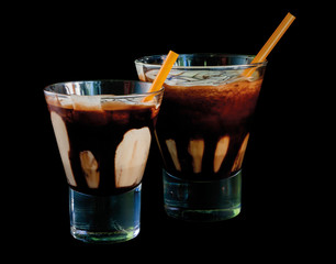 Frappe coffee with cream and melted chocolate isolated on a black background