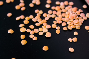 Red lentils in a box on a black background
