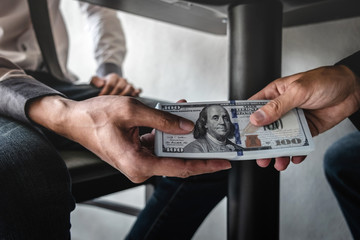Dishonest cheating in business illegal money, Businessman receive bribe money under table to business people to give success the deal contract of investment, Bribery and corruption concept