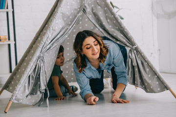 Mother and son in grey wigwam in living room © LIGHTFIELD STUDIOS