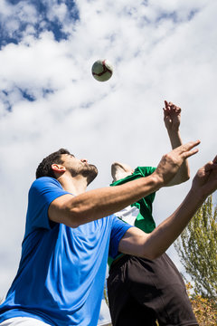 Football players jumping to head the ball during a football match