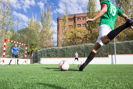 Football player shooting the ball on football field