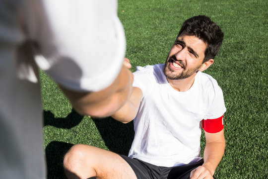 Football player helping an injured player during a match