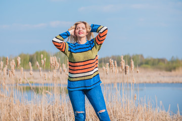 Nice woman in knitted sweater and jeans at forest. Concept of plus size woman, modern beauty and...